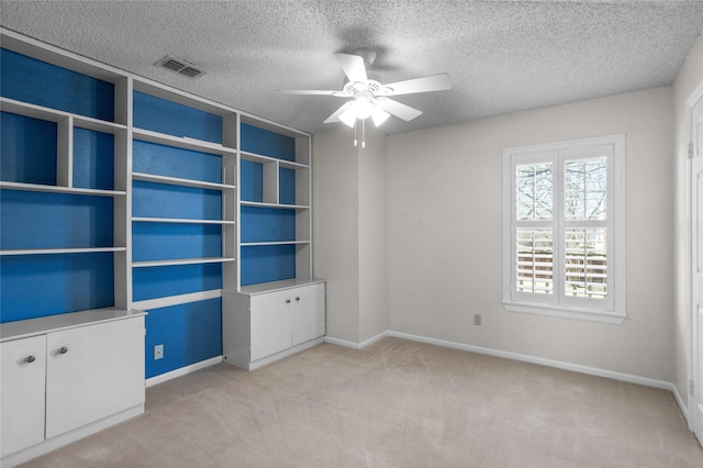 unfurnished room featuring light colored carpet, visible vents, ceiling fan, and baseboards