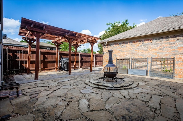 view of patio / terrace with an outdoor fire pit, fence, and a pergola