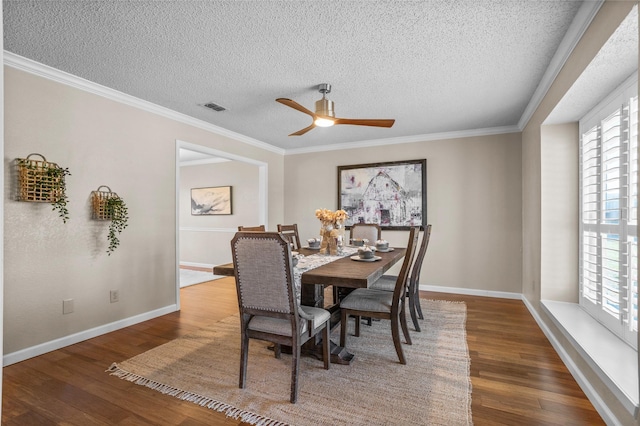 dining room featuring ornamental molding, wood finished floors, visible vents, and baseboards