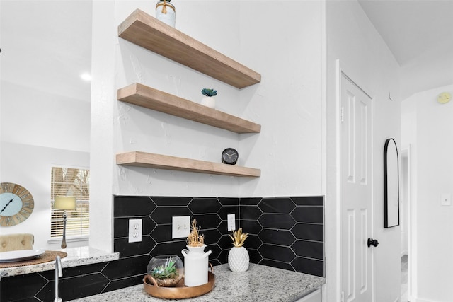 kitchen with light stone counters, a fireplace, and open shelves