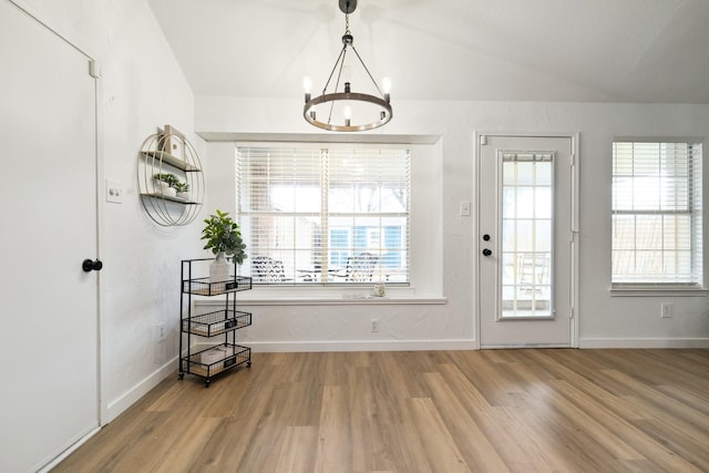 entryway featuring a notable chandelier, baseboards, and wood finished floors