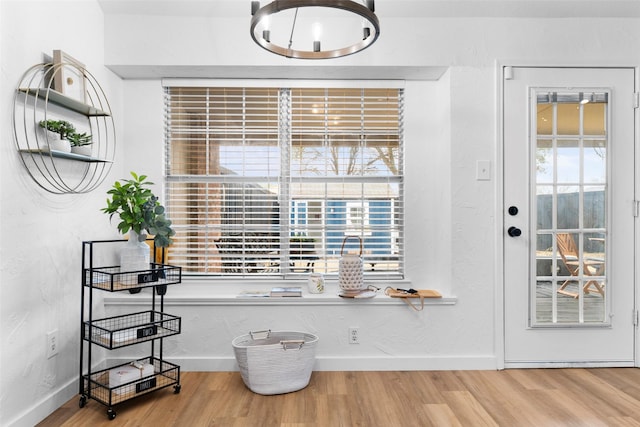 interior space featuring a textured wall, baseboards, and wood finished floors