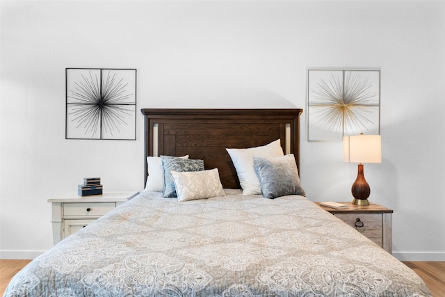 bedroom featuring baseboards and wood finished floors