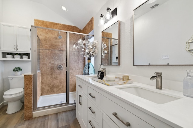 bathroom with a shower stall, vaulted ceiling, a sink, and wood finished floors