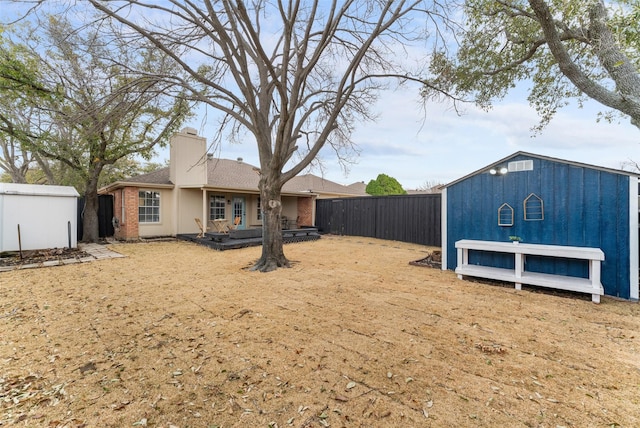 view of yard with an outbuilding, a shed, and a fenced backyard