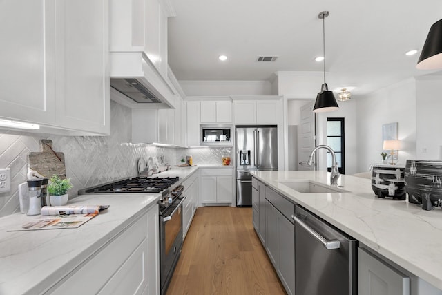 kitchen with high end appliances, a sink, light wood-type flooring, premium range hood, and backsplash