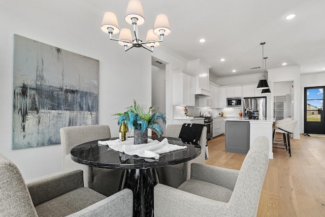 dining space with a notable chandelier, light wood finished floors, recessed lighting, and crown molding