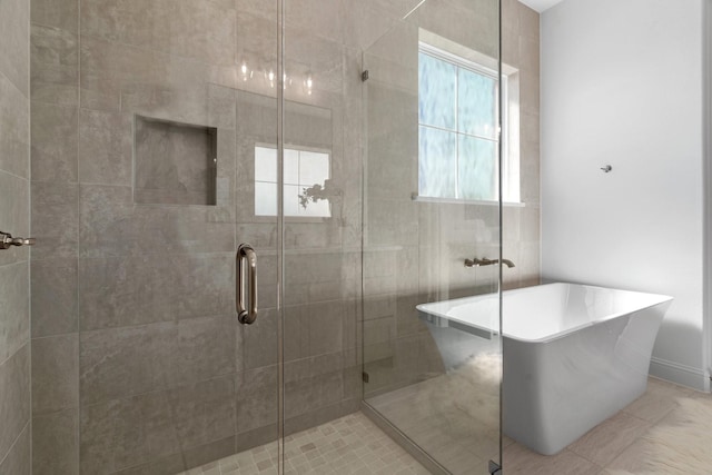 bathroom featuring a freestanding bath and a shower stall