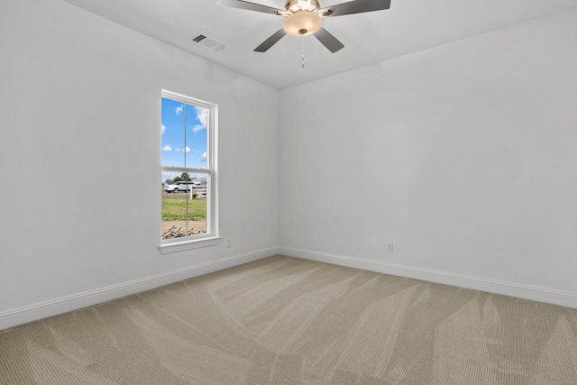 unfurnished room with baseboards, ceiling fan, visible vents, and light colored carpet