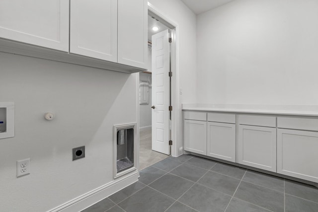 laundry room with gas dryer hookup, hookup for an electric dryer, washer hookup, dark tile patterned floors, and cabinet space