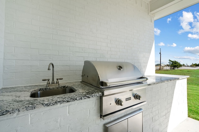 view of patio with a sink, an outdoor kitchen, area for grilling, and fence