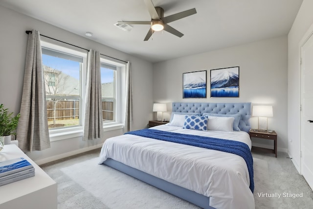 bedroom featuring light colored carpet, ceiling fan, and baseboards