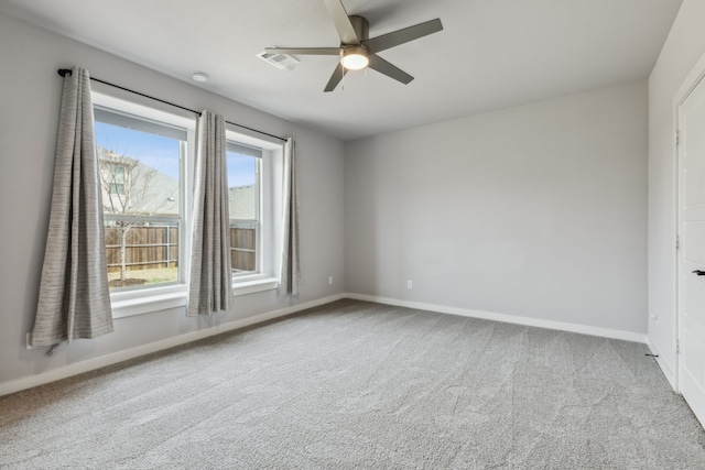 carpeted empty room featuring baseboards and a ceiling fan