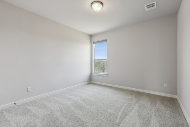 carpeted empty room featuring visible vents and baseboards