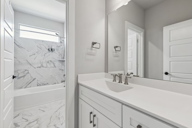 bathroom with marble finish floor,  shower combination, and vanity