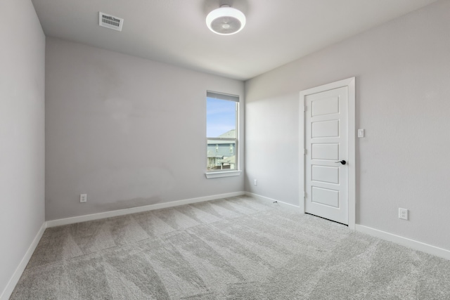 carpeted spare room with visible vents and baseboards