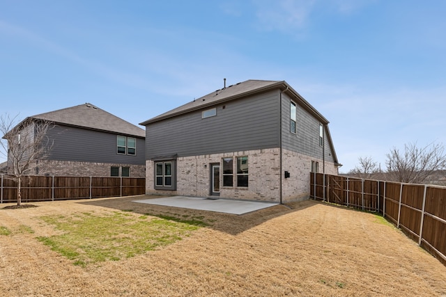 back of property featuring brick siding, a fenced backyard, and a patio