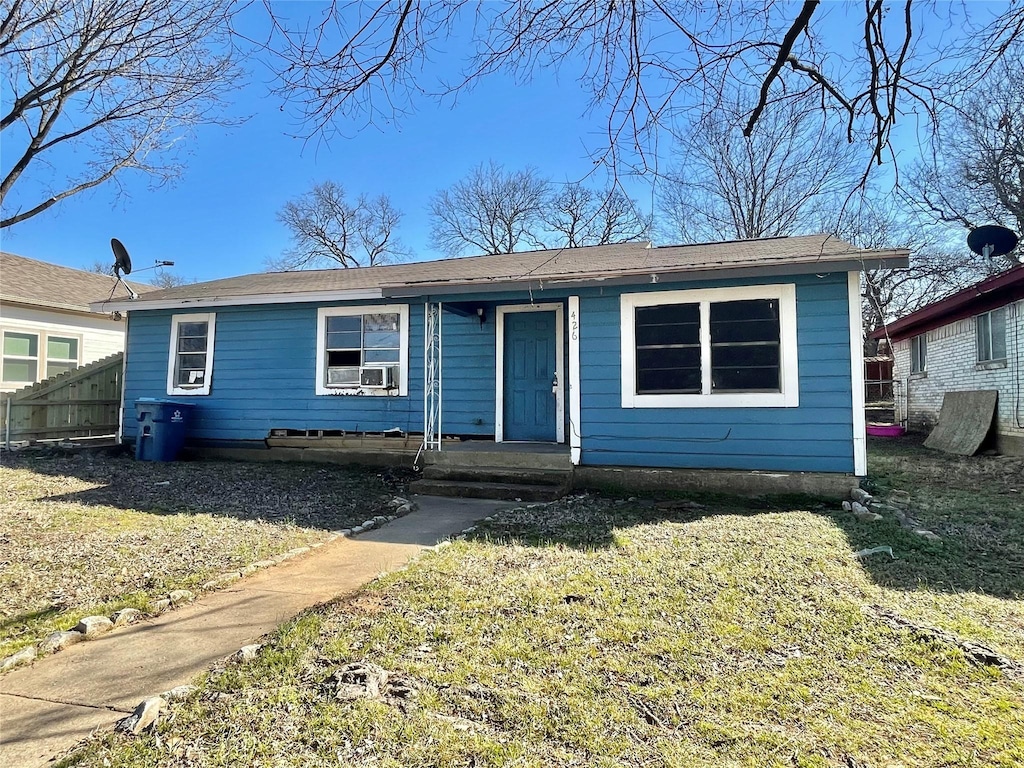 bungalow-style home with a front yard and cooling unit