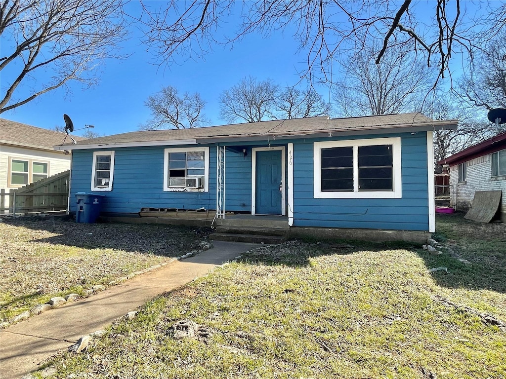 bungalow-style home with a front yard and fence