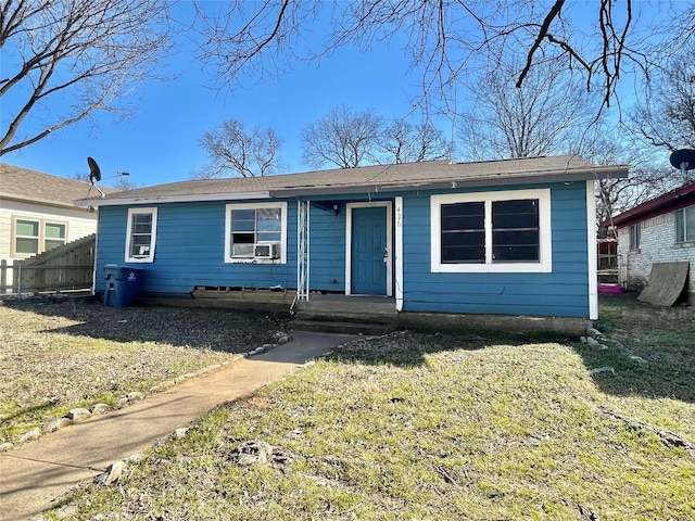 bungalow-style home with a front yard and fence