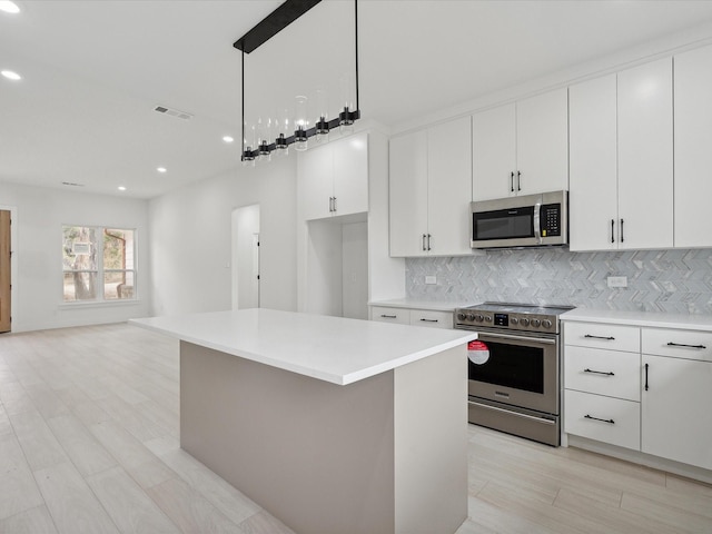 5809 Black Pine Cir, Granbury, TX 76048 - kitchen featuring appliances with stainless steel finishes, a kitchen island, tasteful backsplash, light countertops, and recessed lighting