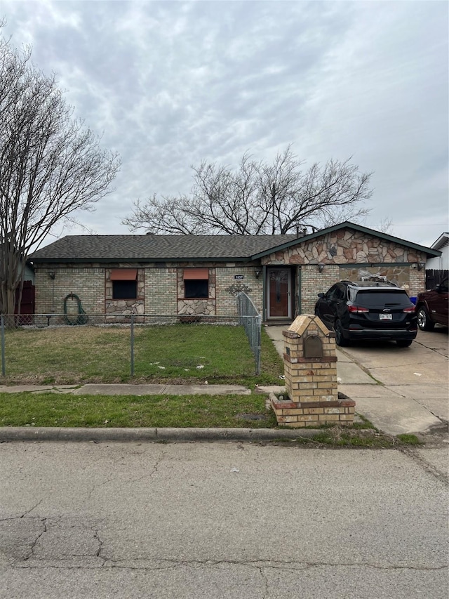 view of front facade featuring a fenced front yard, concrete driveway, a front lawn, and a garage