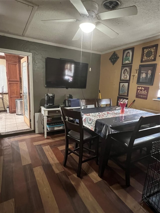 dining room with attic access, a ceiling fan, wood finished floors, a textured ceiling, and crown molding