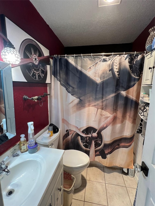 bathroom featuring a textured ceiling, vanity, tile patterned flooring, and toilet