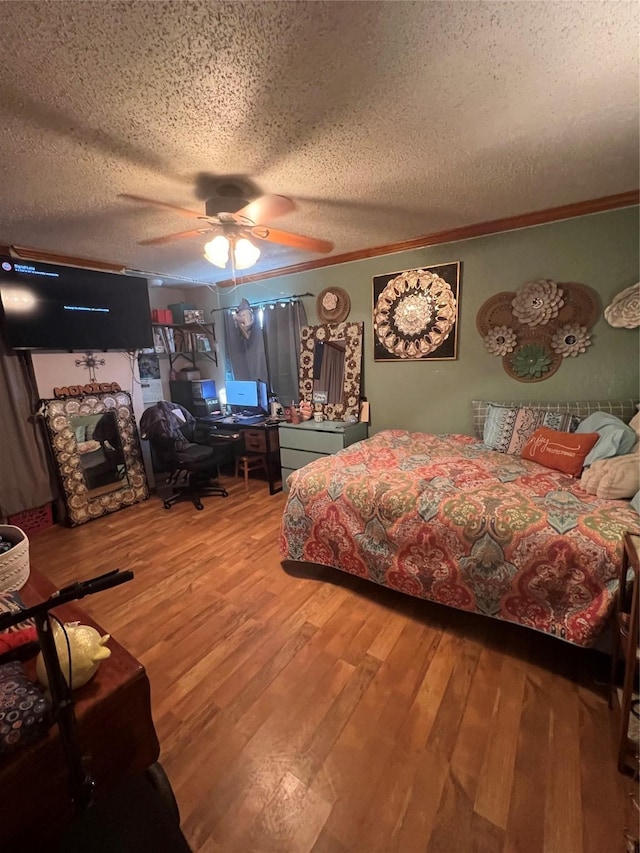 bedroom with a textured ceiling, ceiling fan, wood finished floors, and crown molding