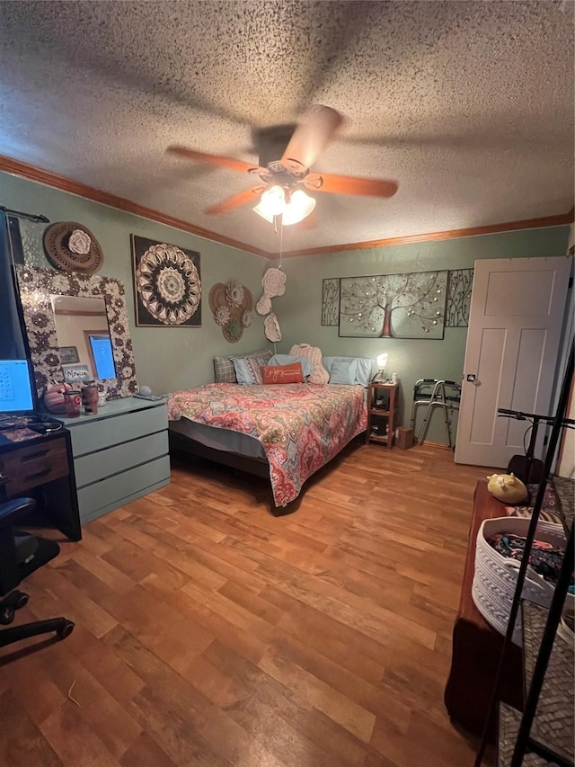 bedroom with a ceiling fan, a textured ceiling, ornamental molding, and wood finished floors