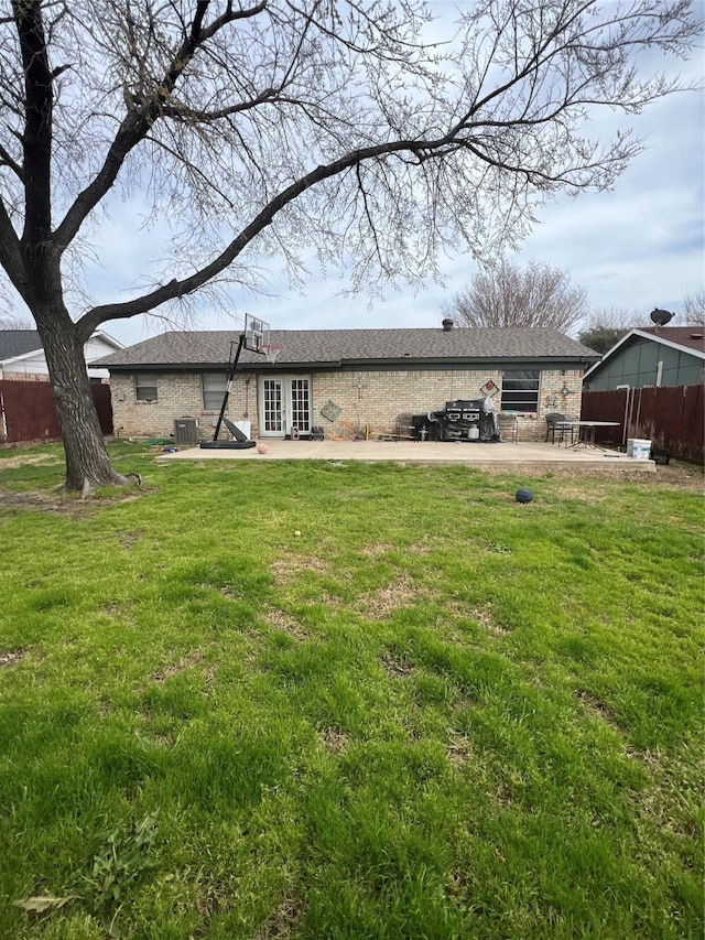 back of house featuring cooling unit, fence, a lawn, and a patio