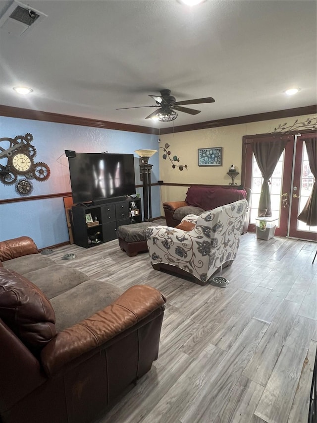 living room featuring ceiling fan, ornamental molding, wood finished floors, and visible vents