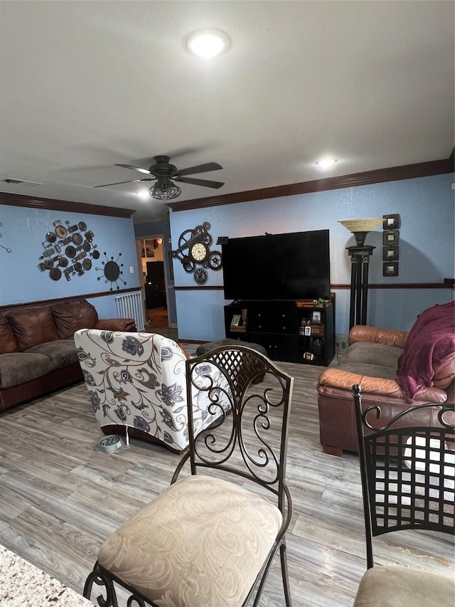 living room featuring ceiling fan, wood finished floors, and crown molding