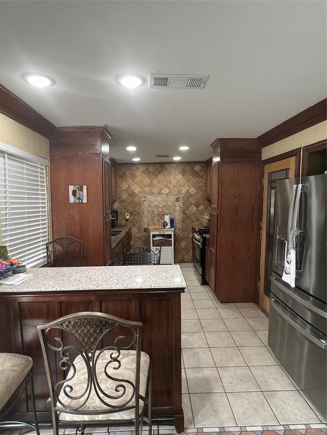 kitchen featuring light tile patterned floors, visible vents, tile walls, light countertops, and appliances with stainless steel finishes