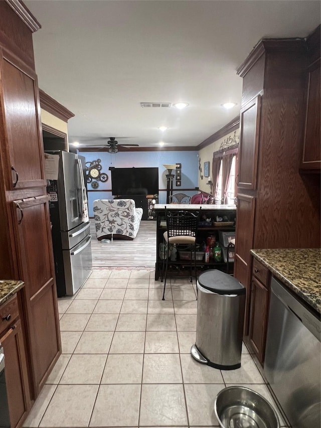 kitchen featuring crown molding, light tile patterned floors, stainless steel appliances, visible vents, and a ceiling fan