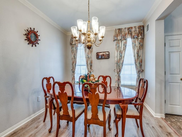 dining space featuring baseboards, visible vents, ornamental molding, a notable chandelier, and light wood-type flooring