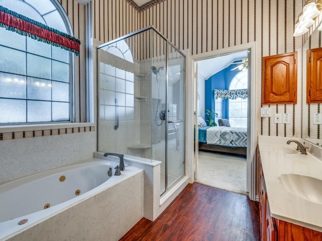 bathroom with a jetted tub, wallpapered walls, a stall shower, ensuite bathroom, and a sink