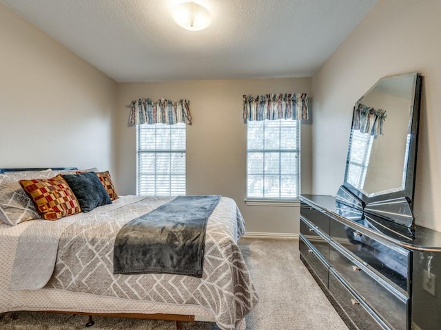 carpeted bedroom featuring baseboards and a textured ceiling