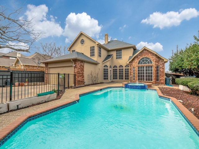 view of pool with a patio area, a pool with connected hot tub, and fence