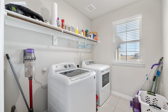 laundry room featuring visible vents, baseboards, light tile patterned floors, laundry area, and independent washer and dryer