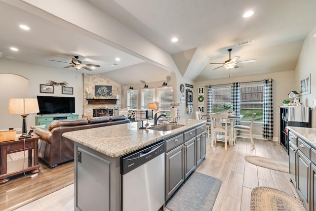 kitchen with lofted ceiling, a sink, visible vents, gray cabinets, and dishwasher