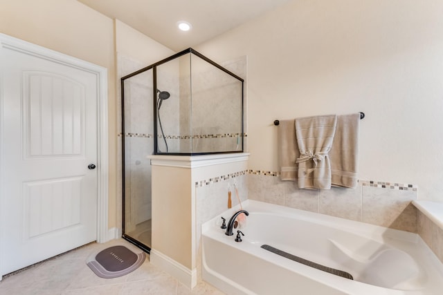 bathroom featuring tile patterned flooring, a shower stall, and a bath