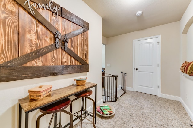 hall with an upstairs landing, arched walkways, and baseboards