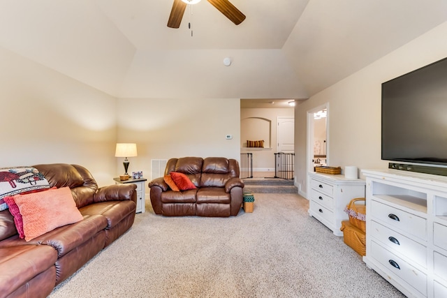 living area featuring ceiling fan, vaulted ceiling, and light colored carpet