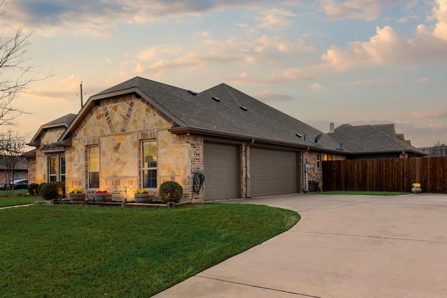 view of front of house featuring a front yard, stone siding, a garage, fence, and concrete driveway