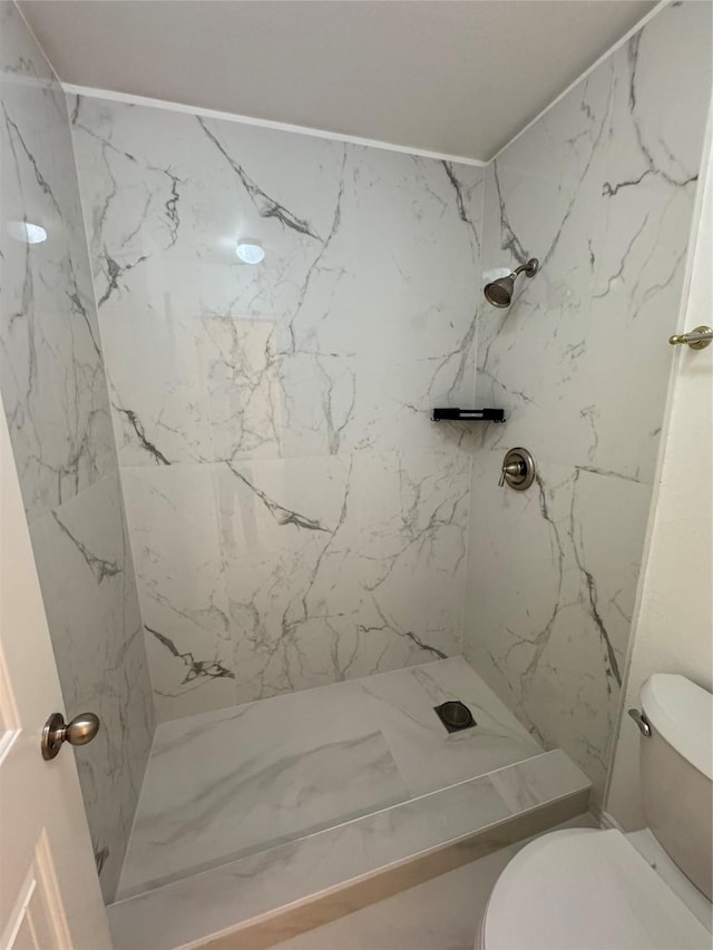 full bath with a marble finish shower and toilet