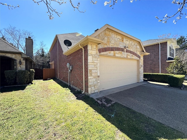 view of side of property with a garage, brick siding, stone siding, driveway, and a lawn