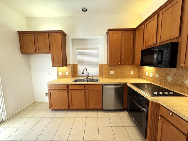 kitchen featuring black appliances, brown cabinetry, and a sink