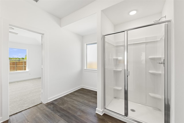 full bath with a shower stall, baseboards, and wood finished floors