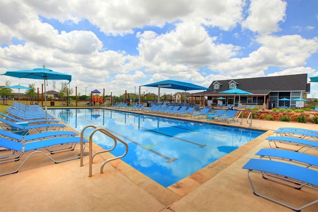 community pool with a patio area and fence